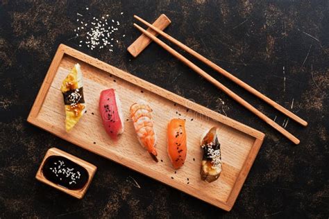 Sushi assortito su un piatto di legno con salsa di soia e bacchette