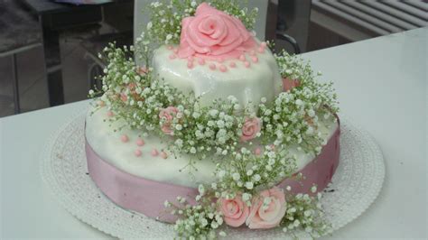 Torta a due piani decorata con fiori e panna